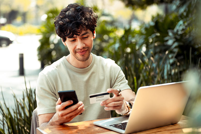 Man uses credit card to make online purchase.