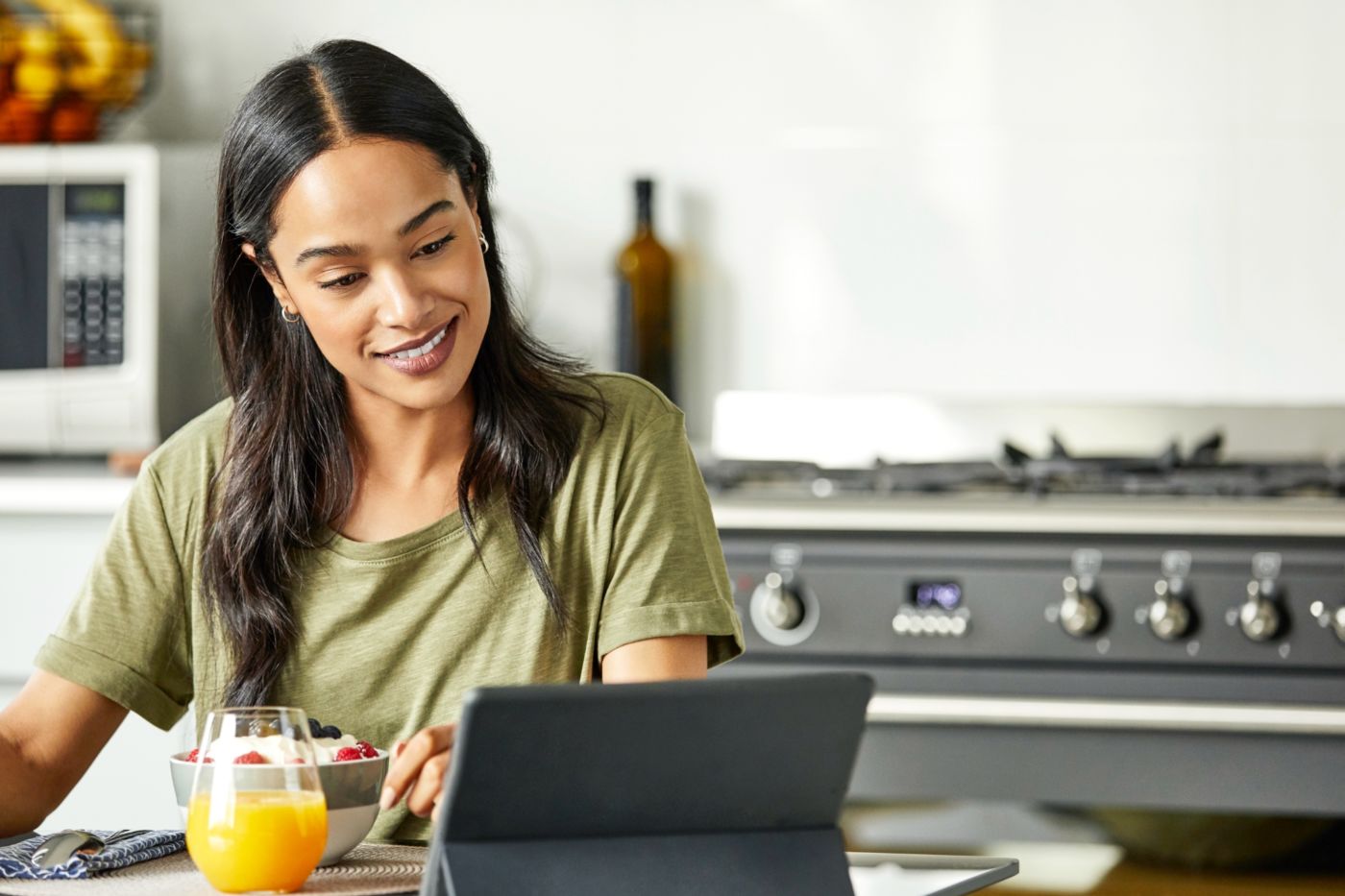 Woman looking at a laptop on her kitchen table.