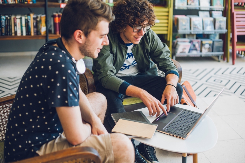 two friends looking at creative ways to pay off student loans